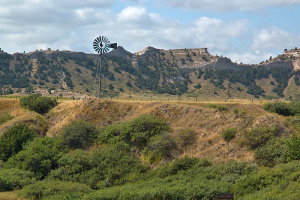 内布拉斯加州西部牧场的风车向牲畜抽水 背景为悬崖 — 图库照片