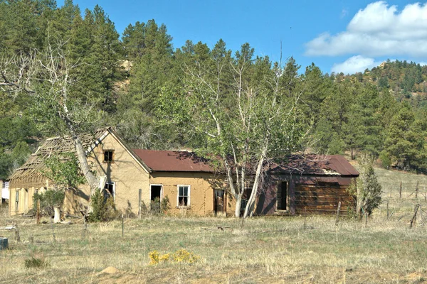 Abandoned Adobe home and log out buildings