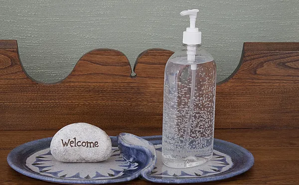 Sanitizer tangan pada piring unik dengan tanda selamat datang — Stok Foto