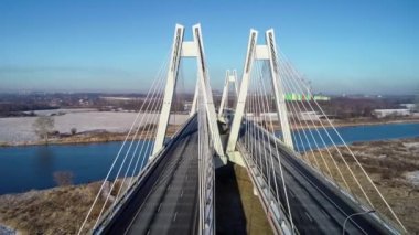 Yeni modern Macharski Polonya 'nın Krakow kentindeki Vistula Nehri üzerinde üç şeritli asma köprü olarak kaldı. Krakow çevresindeki çevre yolunun bir parçası. Kışın Aerial 4K videosu