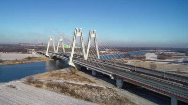 Yeni modern Macharski Polonya 'nın Krakow kentindeki Vistula Nehri üzerinde üç şeritli asma köprü olarak kaldı. Krakow çevresindeki çevre yolunun bir parçası. Kışın 4K hava aracı yaklaşıyor.