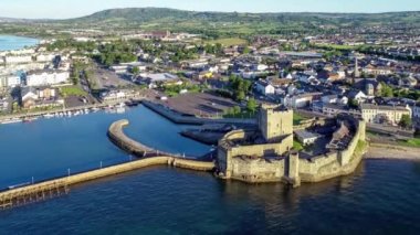 Belfast Lough, Carrickfergus 'taki Ortaçağ Norman Kalesi' nde gün doğumunda Belfast yakınlarında. Hava 4K marina, dalgakıran, yatlar, park alanı, kasaba ve arka planda Belfast manzaralı bir video yayınladı.