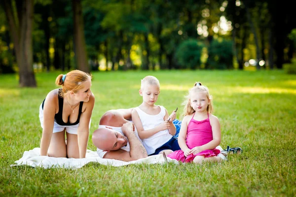 En lykkelig familie i en park – stockfoto