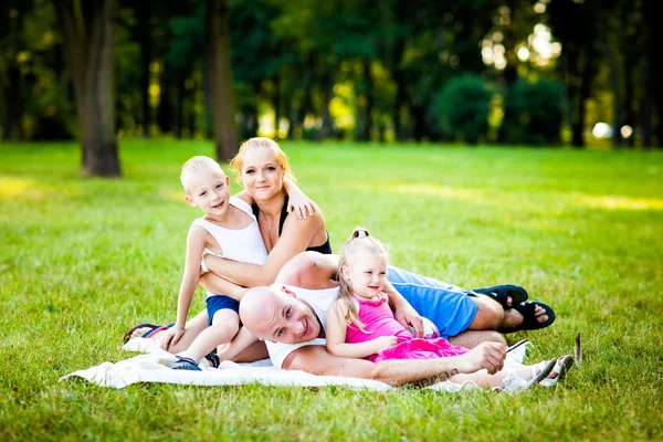 En lykkelig familie i en park – stockfoto