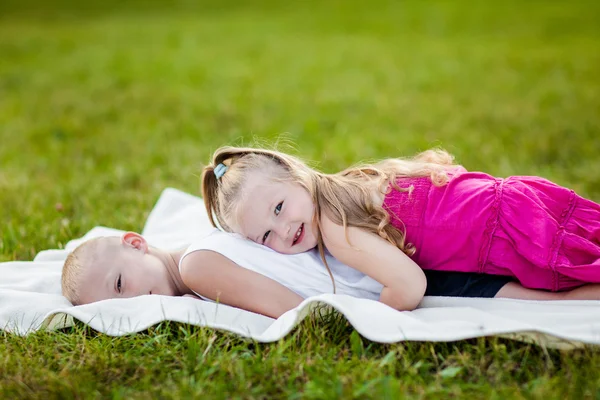 Gelukkig weinig meisje en jongen in een park — Stockfoto