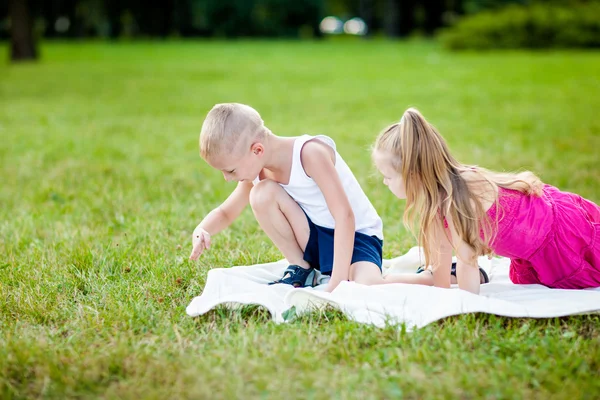 Gelukkig weinig meisje en jongen in een park — Stockfoto