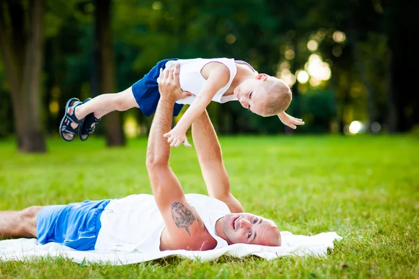 Far og barn som har det gøy i parken – stockfoto