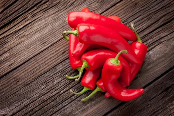 Färsk röd chili på ett träbord — Stockfoto
