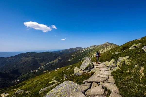 Senior man on a path around Chopok and Dumbier mountain with Stefanika shelter  - in slovakian low Tatra mountains. Summer panorama with great weather and blue sky