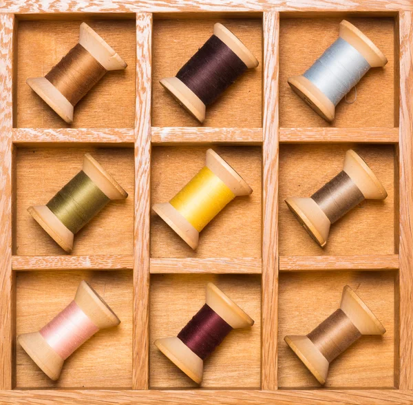 Wooden shadow box with thread spools — Stock Photo, Image