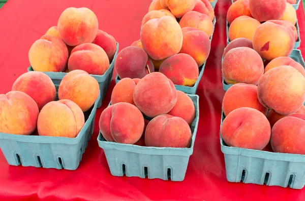 Korgar av persikor till salu på marknaden — Stockfoto
