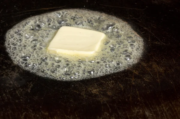 Butter bubbling on hot griddle — Stock Photo, Image