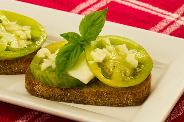 Φρέσκο Μπρουσκέτα με πράσινο κειμήλιο ντομάτες τυρί και βασιλικό — Φωτογραφία Αρχείου
