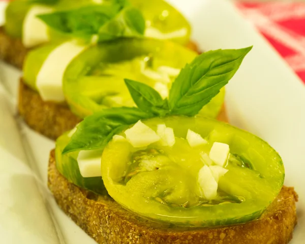 Bruschetta proaspătă cu roșii verzi cu brânză și busuioc — Fotografie, imagine de stoc