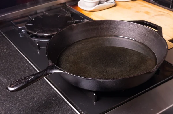 Cast iron skillet or fry pan on stove — Stock Photo, Image