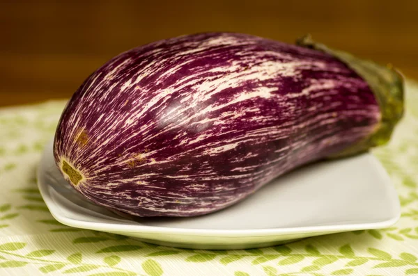 Purple striped eggplant on plate — Stock Photo, Image