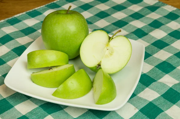 Granny smith äpple skivor på vit platta — Stockfoto