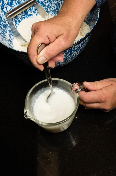 Baker adding ingredients to mixing bowl — Stock Photo, Image