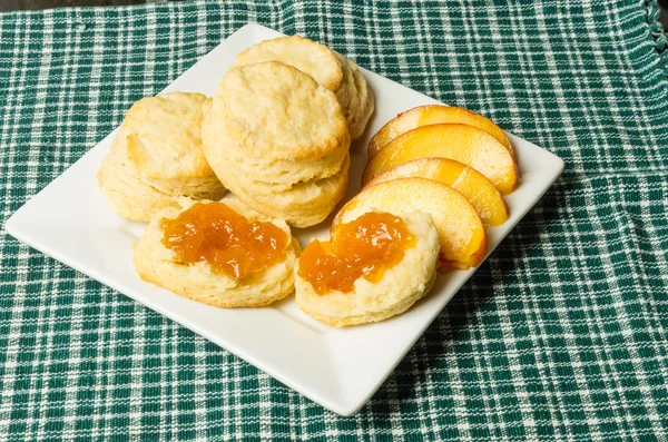 Біла тарілка з печивом та персиками — стокове фото