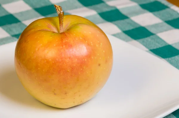 Pink Pearl apple on a white plate — Stock Photo, Image