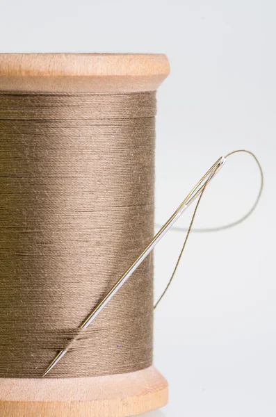 Spool of brown threas with a needle — Stock Photo, Image