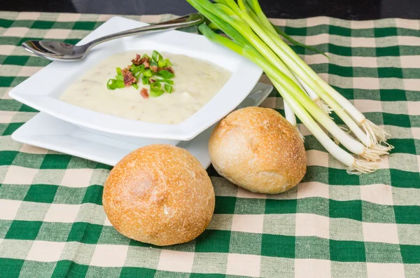 Bowl of potato leek soup with rolls — Stock Photo, Image