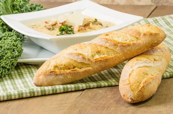 Loaves of bread with bowl of soup — Stock Photo, Image