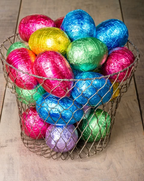 Wire egg basket with colorful eggs — Stock Photo, Image