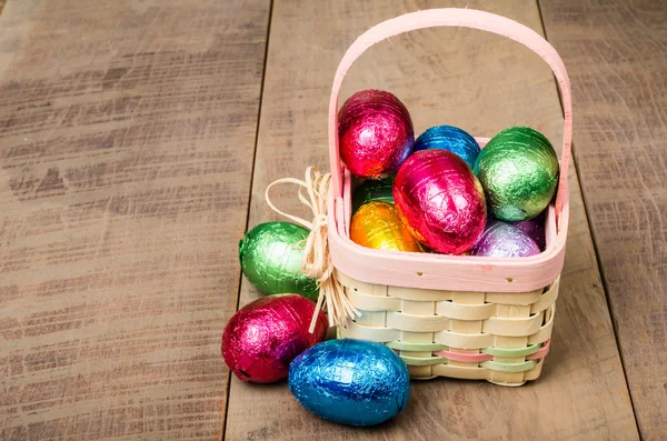 Wicker Easter basket with foil chocolate eggs — Stock Photo, Image