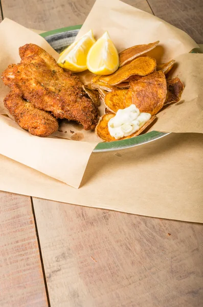 Pescado y patatas fritas en una mesa de madera — Foto de Stock