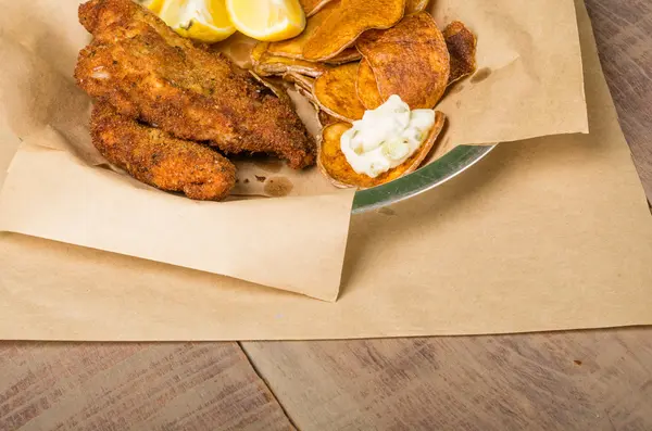 Pescado y patatas fritas en una mesa de madera — Foto de Stock