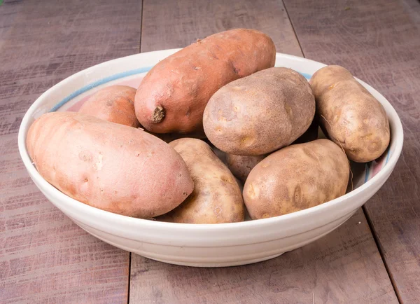 Bowl of potatoes on wooden table — Stock Photo, Image