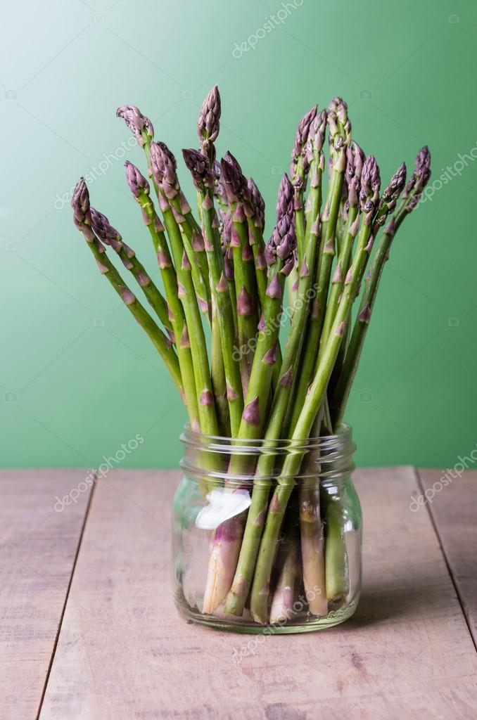 Fresh green asparagus in a glass jar — Stock Photo © zigzagmtart 23687941