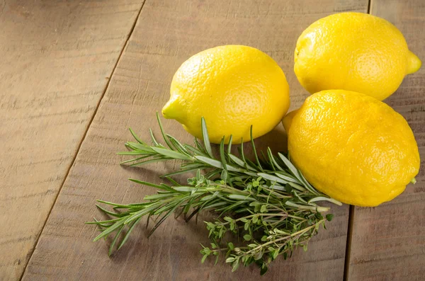Lemons and herbs on a wooden table — Stock Photo, Image