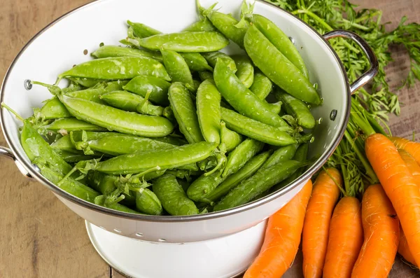 Frische grüne Erbsen und Karotten — Stockfoto