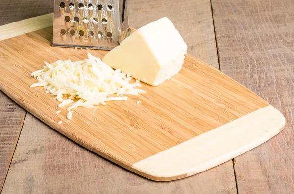 Parmesan cheese grated on a cutting board — Stock Photo, Image