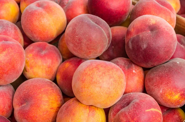 Färska gula persikor på displayen på marknaden — Stockfoto