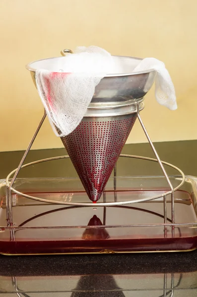 Filtering fresh strawberries to make jelly — Stock Photo, Image