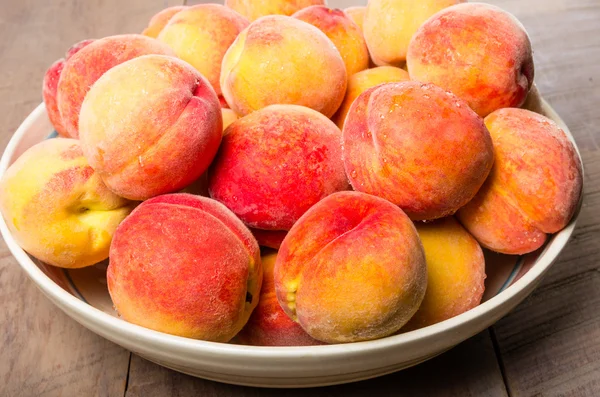 Чаша свежих желтых персиков — стоковое фото