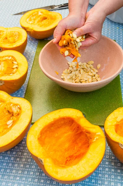 A cook extracting the seeds from a pumpkin — Stock Photo, Image