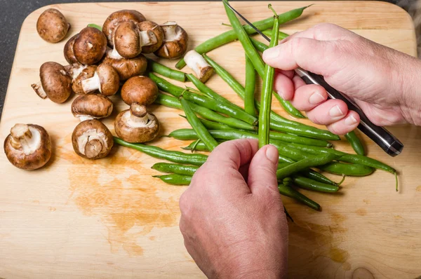 Cook cutting green beans in kitchen — Stock Photo, Image