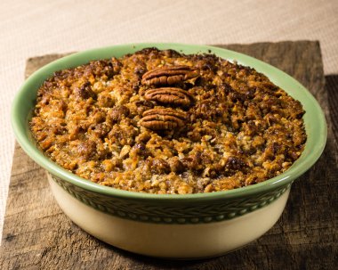 Baked sweet potato casserole with pecan topping clipart