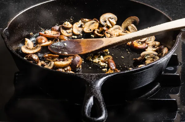 Sauteing gesneden champignons in een koekepan — Stockfoto