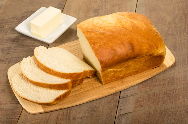 Loaf of sliced bread with butter plate — Stock Photo, Image