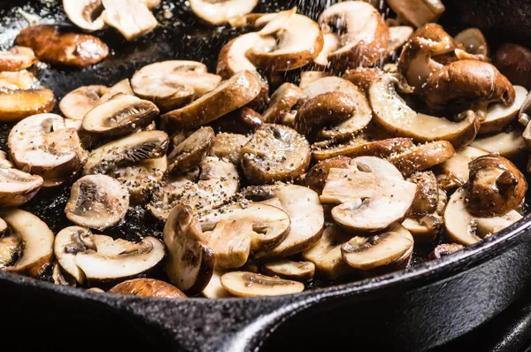 Sauteing szeletelt gombát egy serpenyőben — Stock Fotó