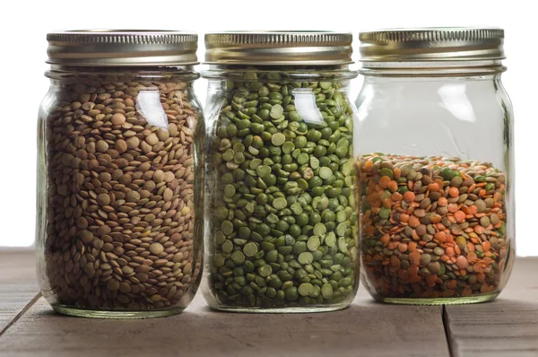 Jars of lentils on a counter — Stock Photo, Image