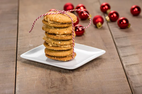 Stack of cookies on white plate with red balls — Stock Photo, Image