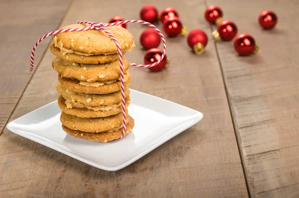 Stack of cookies on white plate with red balls — Stock Photo, Image