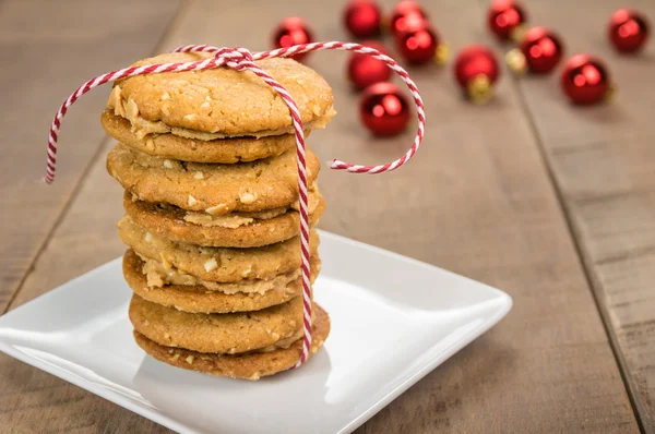 Stack of cookies on white plate with red balls — Stock Photo, Image