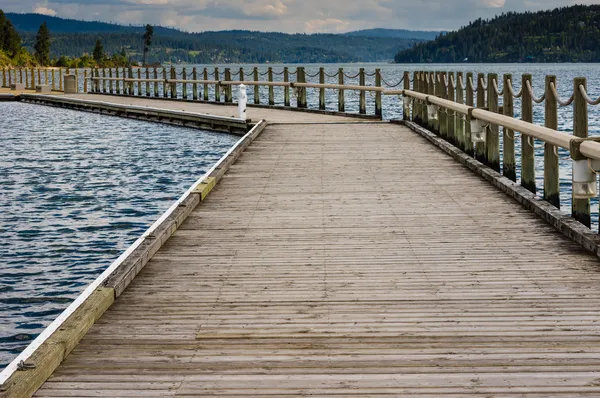 Pier de madeira ou doca que se estende em um lago — Fotografia de Stock